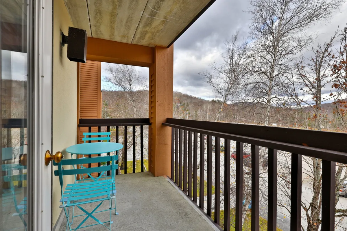 The private patio invites guests to step outside with a turquoise table and metal chairs set against a backdrop of trees and mountains. It’s a serene spot for morning coffee, fresh air, or taking in Vermont’s natural beauty after a day on the slopes.